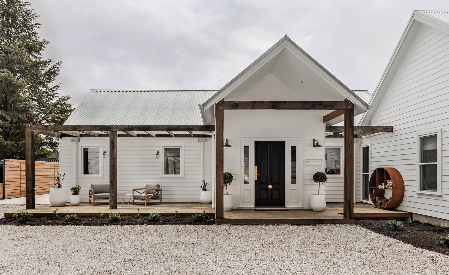 Modern barn home with white weatherboard, blending tradition with sleek architecture in Burrawang, NSW.