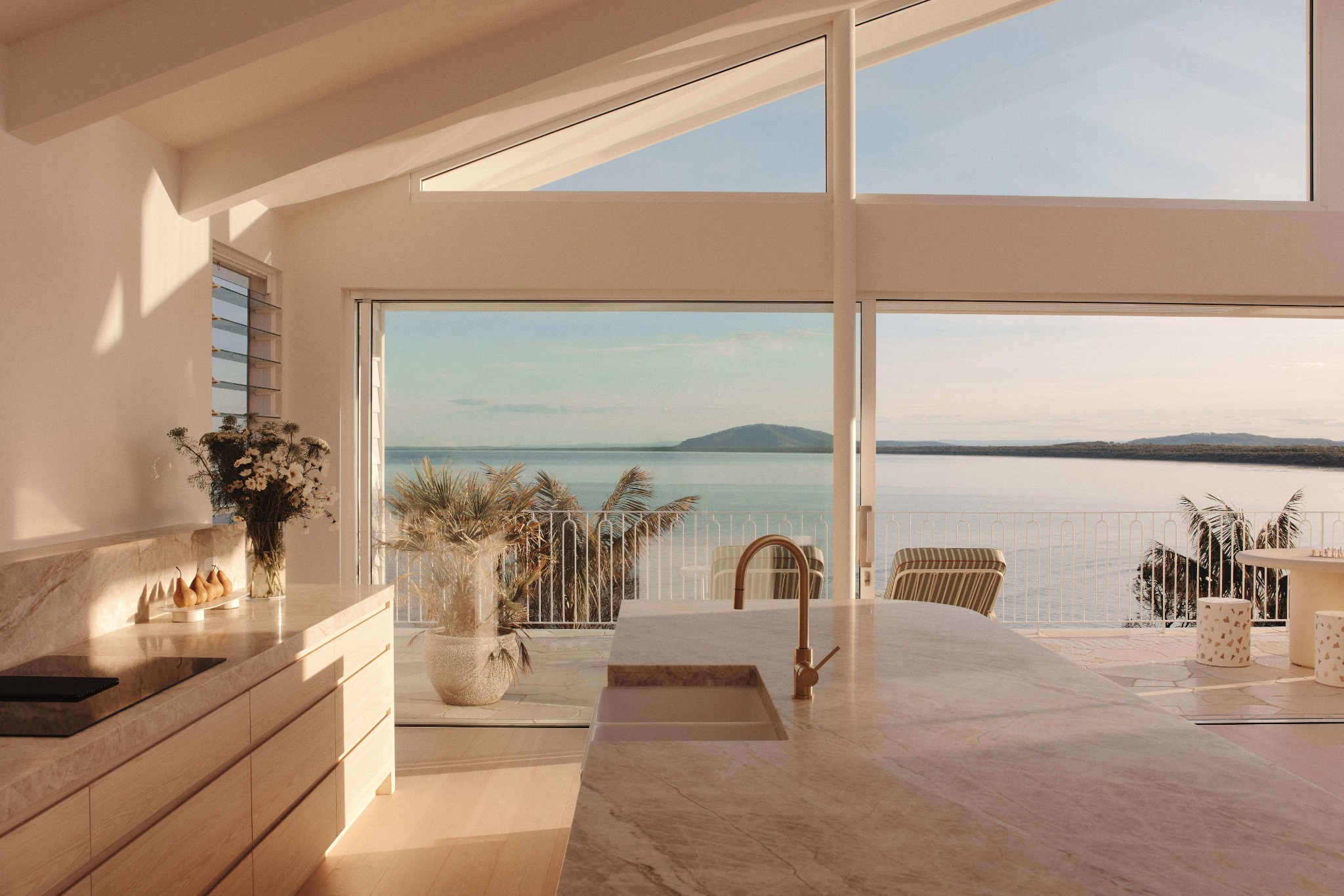 Sunset dining area with indoor-outdoor flow in a luxury Gerroa home by Lime Building Group
